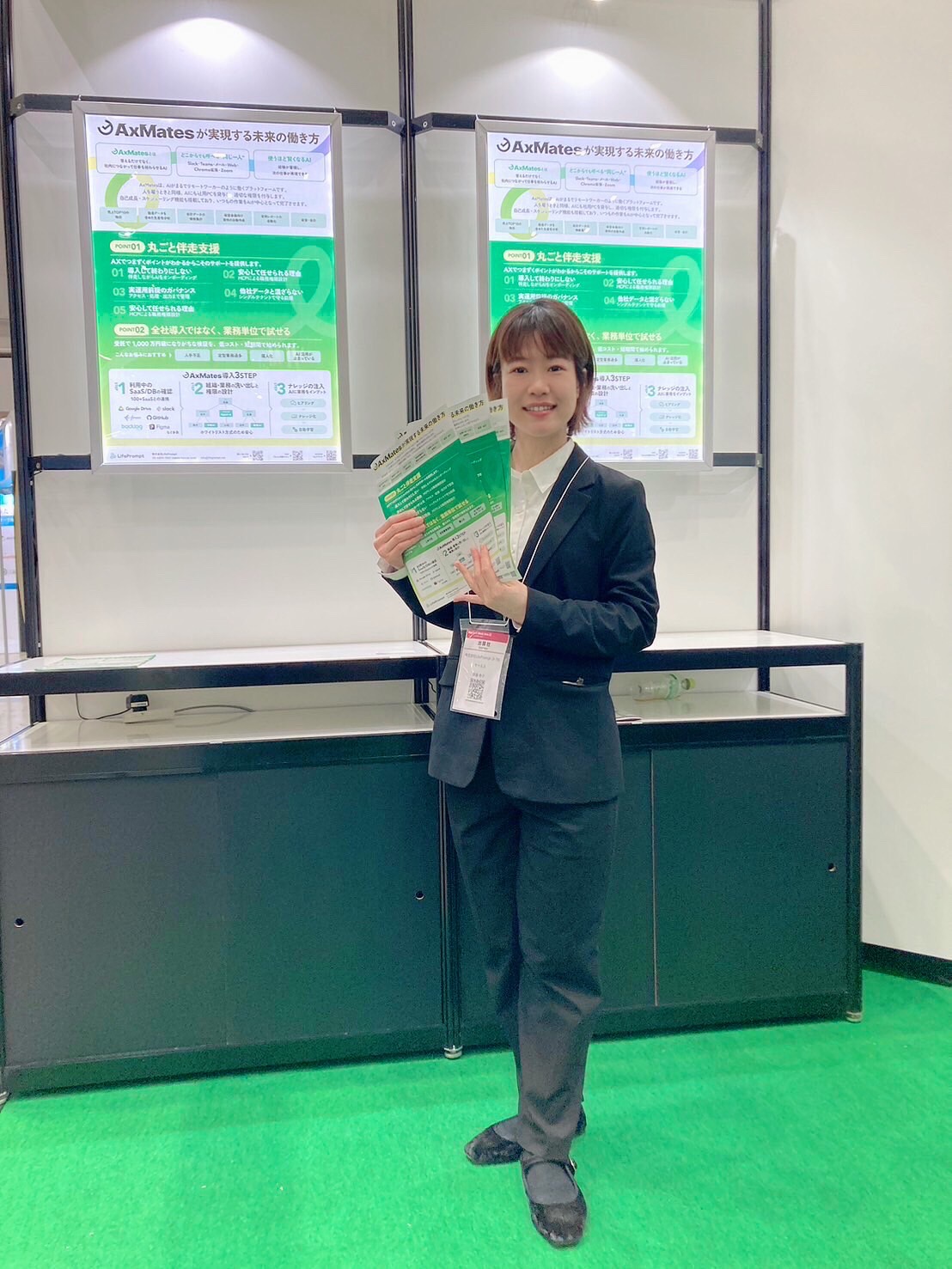 スーツスタイルで接客するイベントコンパニオン